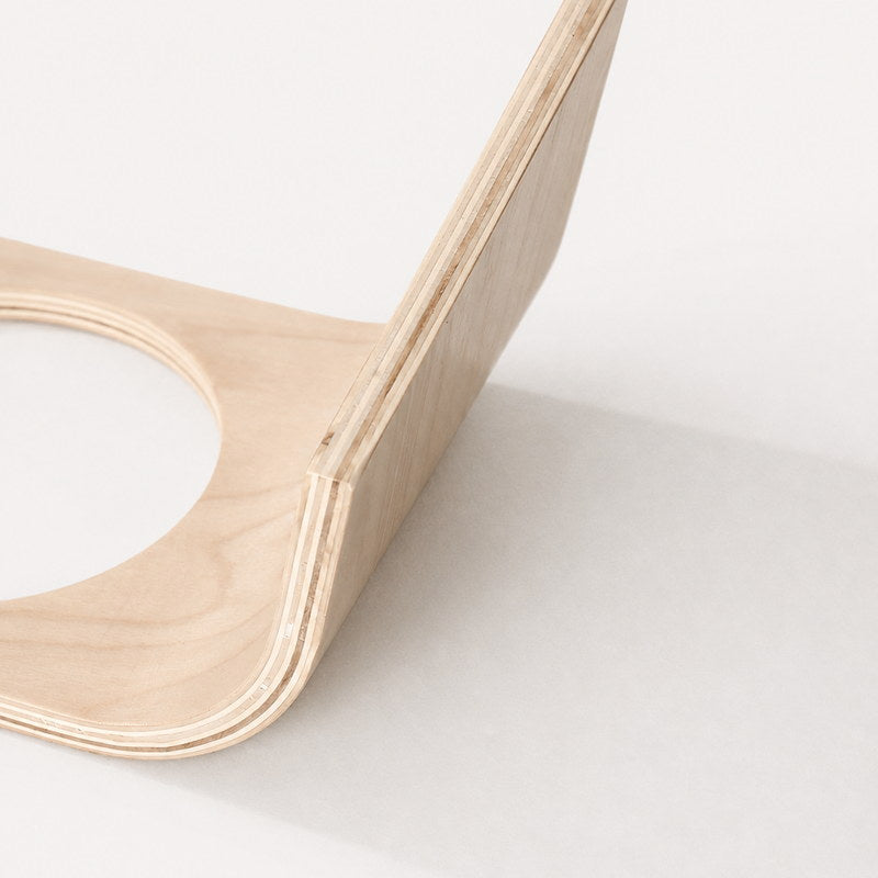 Close-up of the layered plywood edge and curved stand construction