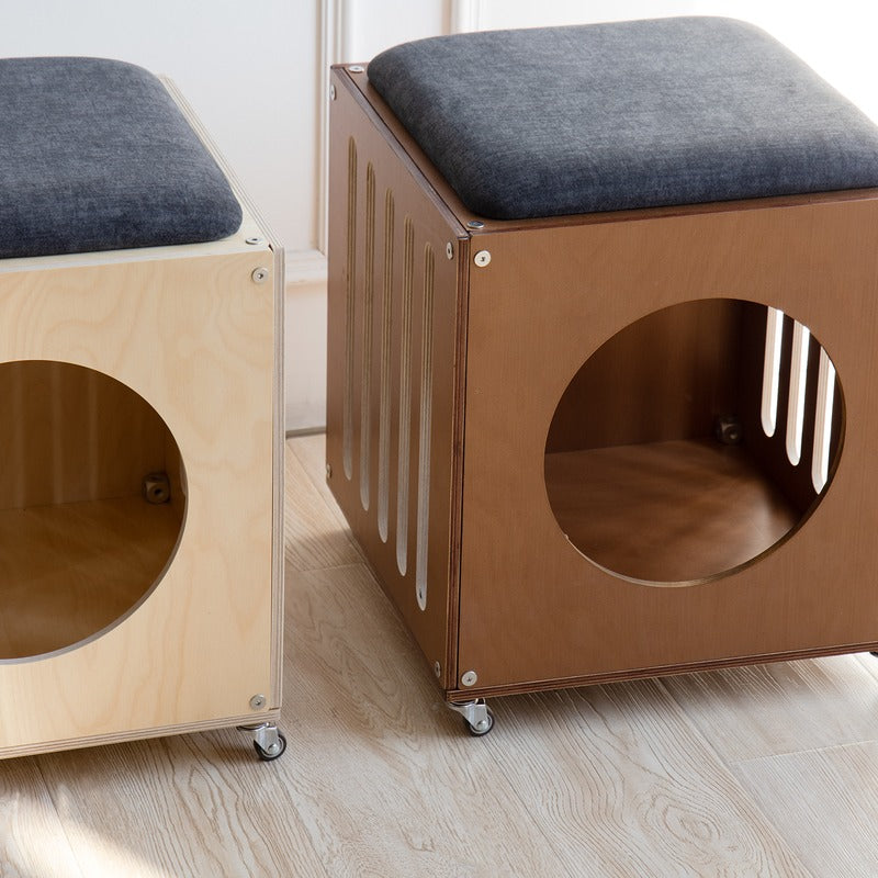 Natural and walnut-finish Haven Cat House Stools shown together with dark seat cushions
