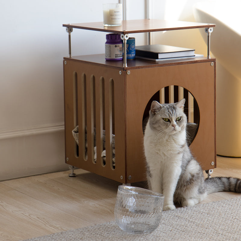 Cat sitting beside the walnut-finish CheerMoe Haven Cat House in a sunlit room