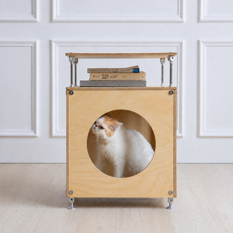 CheerMoe Haven Cat House in natural birch plywood with a white cat resting inside