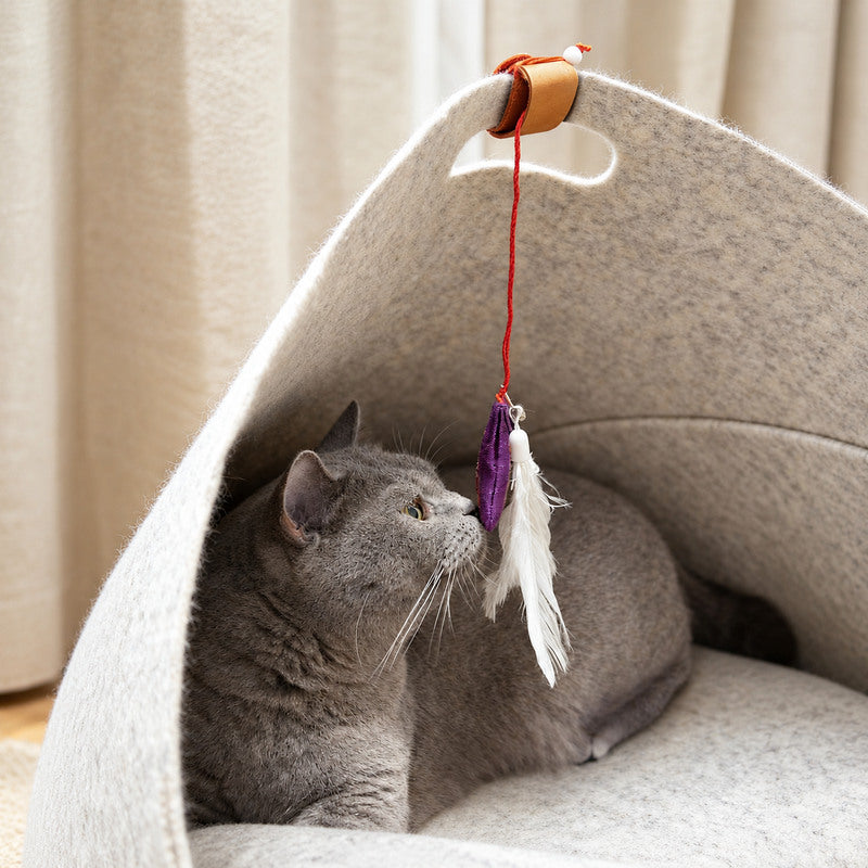 Gray cat playing with a feather toy inside the CheerMoe Pica foldable felt pet nest