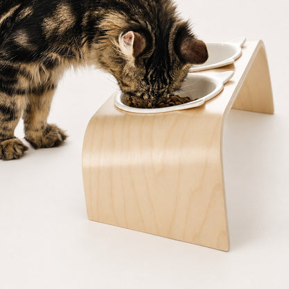 Close side view of a cat eating from the raised cat-ear bowl